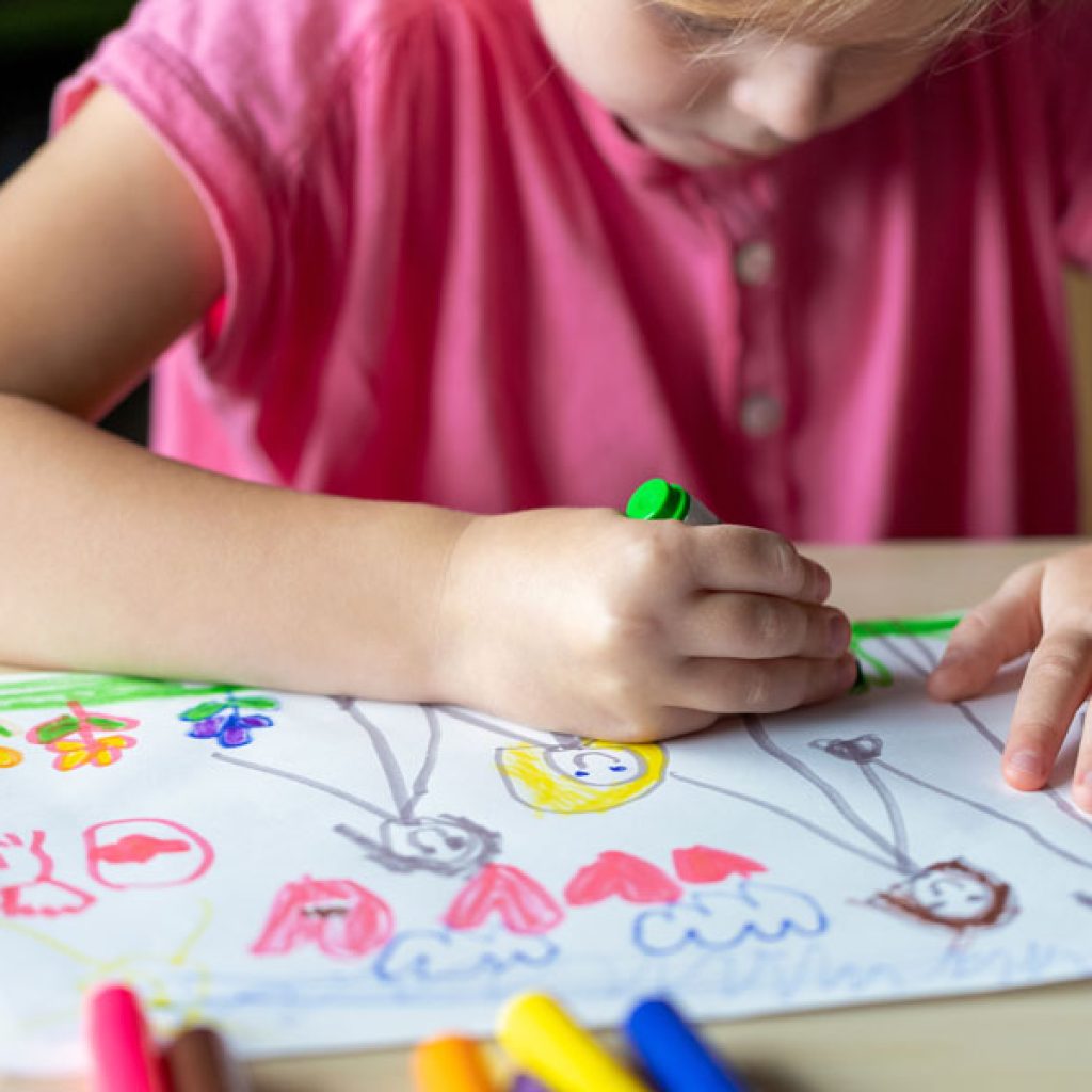 Child coloring on a piece of paper at Discovery Corner Academy